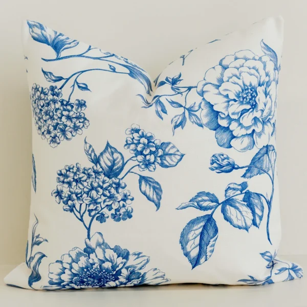 Large blue botanical floral cushion cover on cream cotton-linen fabric.
