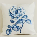 Cream cushion cover with large blue hand-drawn rose print.