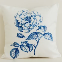 Cream cushion cover with large blue hand-drawn rose print.
