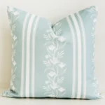 Sage green striped cushion cover with white floral vine detail.
