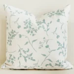 Sage green botanical sprig cushion cover on cream cotton-linen.