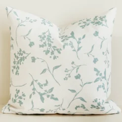Sage green botanical sprig cushion cover on cream cotton-linen.