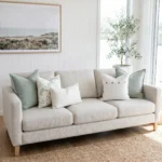 Five-piece cushion set with two sage blocks, a botanical print, and button and boucle lumbar accents, on a sofa.